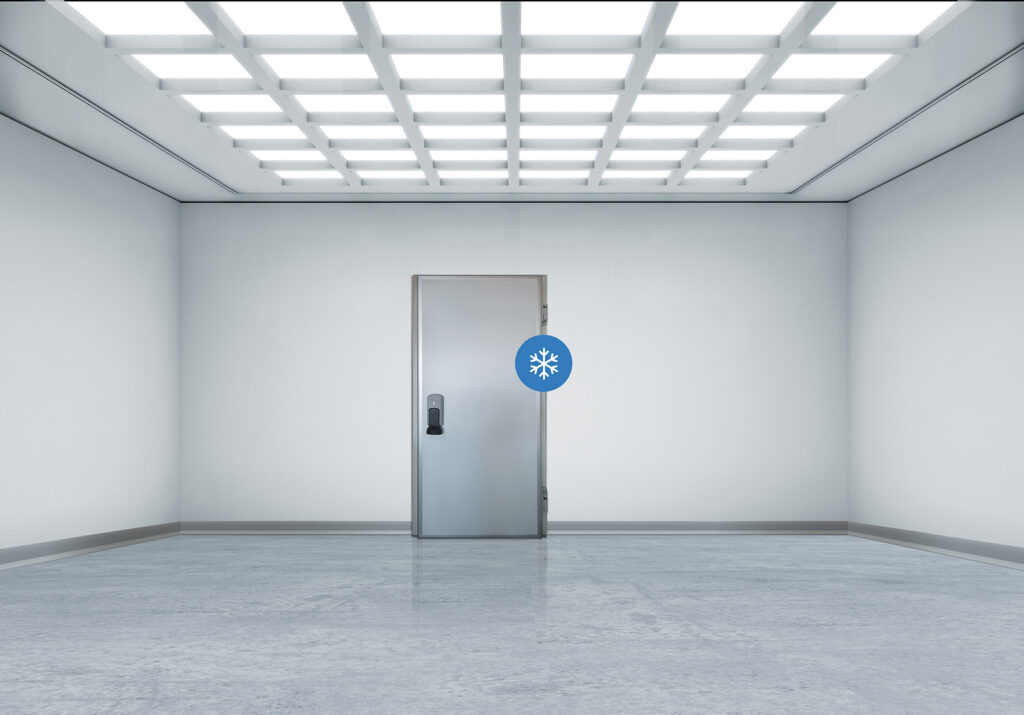 Empty white room with a stainless freezer door marked with a snowflake.