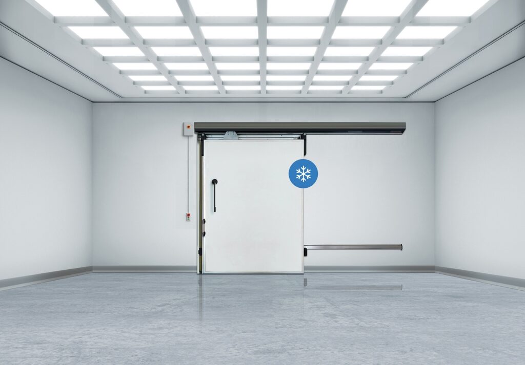 Sterile industrial room with sliding freezer door under grid lights