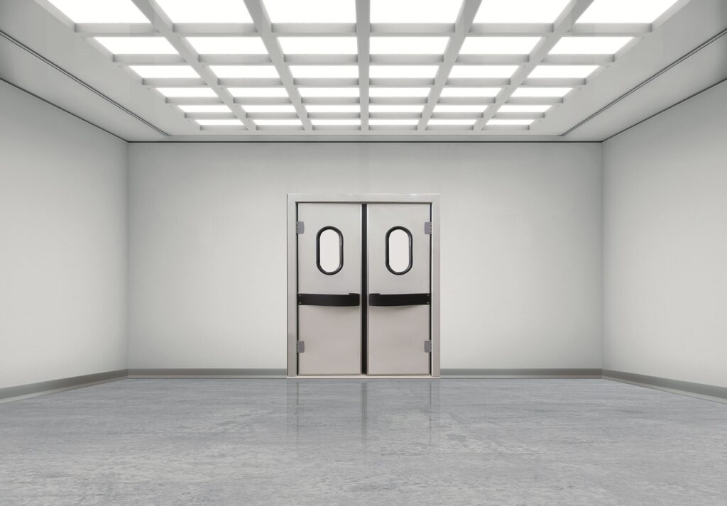 Clean, empty room with double swing doors and bright grid ceiling lights.
