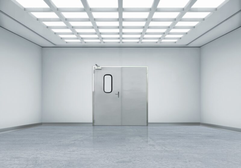 Minimal white room with grid ceiling lights and stainless double door