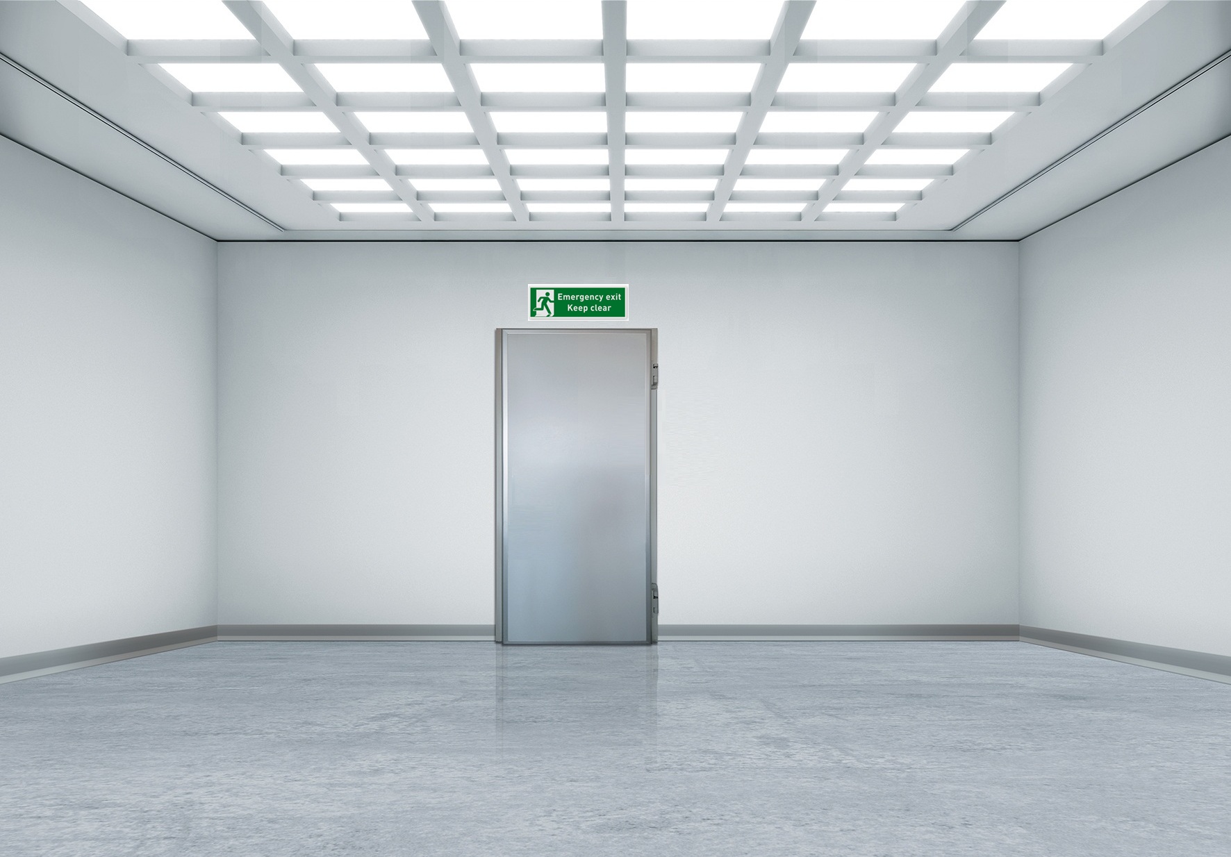 Empty white room with metal door and emergency exit sign above.
